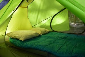 a bed in a green tent with a pillow at Fitz Roy Comfort Camp - El Chaltén in El Chalten