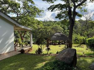 a garden with a gazebo next to a house at StoneWoodGrey in Harare