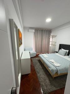 a bedroom with a bed and a chair in it at Hotel Campo Pequeno in Lisbon