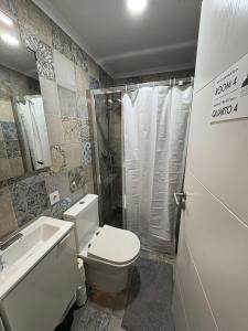 a bathroom with a toilet and a shower and a sink at Hotel Campo Pequeno in Lisbon