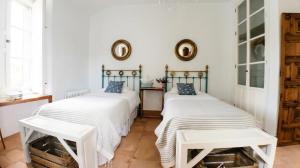 two beds in a room with white walls at La Escribana in Constantina
