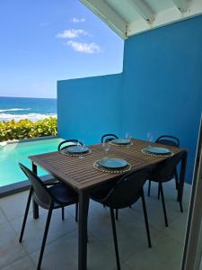a wooden table with chairs and a blue wall at Villa Aura in Oyster Pond