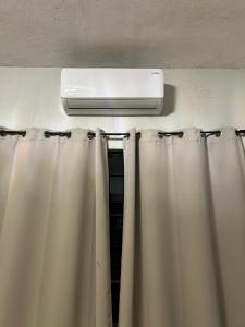 a room with curtains and a air conditioner on the wall at Casa Tierra Mia in Tequila