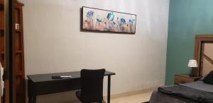 a bedroom with a desk with a chair and a picture on the wall at Casa Tierra Mia in Tequila
