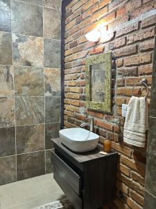 a bathroom with a sink and a brick wall at Casa Tierra Mia in Tequila