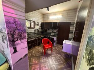 a kitchen with a red chair in a room at Jacobs Cottage KG-G1 in Thiruchendur