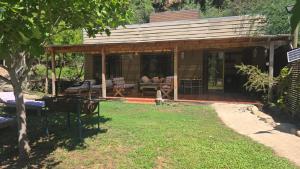 a wooden house with a patio and a yard at Radal Riverside Lodge in El Torreón +9 photos