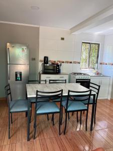 a kitchen with a table and chairs and a refrigerator at Radal Riverside Lodge in El Torreón
