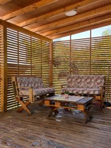 a screened in porch with two benches and a coffee table at Radal Riverside Lodge in El Torreón