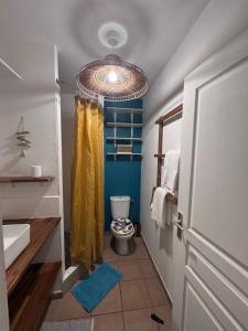 a bathroom with a toilet and a yellow shower curtain at Sxm Caribbean Nest in Saint Martin