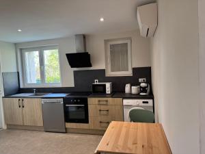 a small kitchen with a table and a microwave at Logis Le Pagnon in Brive-la-Gaillarde +11 photos