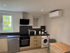 a kitchen with a washer and a stove top oven at Logis Le Pagnon in Brive-la-Gaillarde