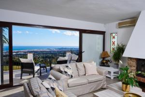 a living room with a couch and a large window at Villa El Capricho in Mijas