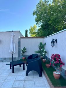 a patio with a table and chairs and a umbrella at Etel Departamentos in San Rafael