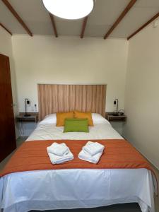 a bedroom with a large bed with two towels on it at Etel Departamentos in San Rafael +28 photos