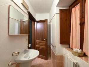 a bathroom with a sink and a toilet and a mirror at Casa Cuoco in Civita Campomarano