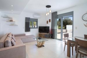 a living room with a couch and a tv and a table at Valora Villa in Nydri