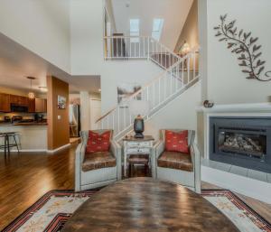 a living room with a table and chairs and a staircase at Meadow Lake Townhouse For 6ppl in Columbia Falls