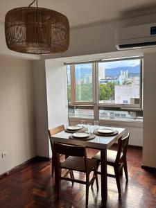 a dining room with a table and chairs and a window at La Plaza Apart in Mendoza