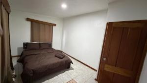 a bedroom with a bed and a wooden door at Blissfull Corner at Centerpoint Unit 1 in Suva