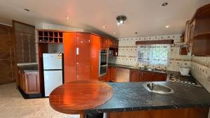 a kitchen with a wooden table and a white refrigerator at Blissfull Corner at Centerpoint Unit 1 in Suva