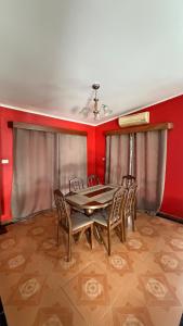 a dining room with a table and chairs and red walls at Blissfull Corner at Centerpoint Unit 1 in Suva