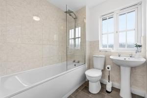 a white bathroom with a toilet and a sink at Comfort Lodge - Modern 5 bed house w 2 bathrooms, parking & gardens in Solihull +20 photos