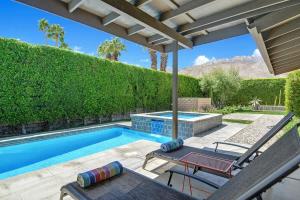 a swimming pool with a patio with a table and chairs at Alejo Olive Orchard - Alice Lodging in Palm Springs
