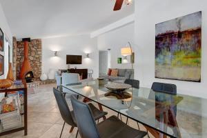 a dining room with a glass table and chairs at Alejo Olive Orchard - Alice Lodging in Palm Springs +27 photos