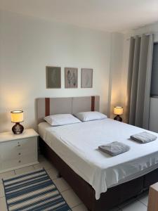 a bedroom with a large bed and two lamps at Apartamento no centro com ar-condicionado in Piracicaba