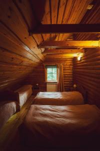 a bedroom with two beds in a log cabin at Irvese Puhkemaja in Haanja