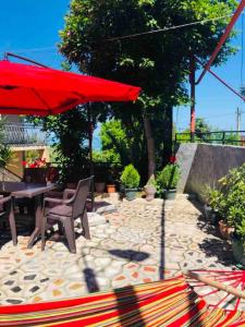 a patio with a table and a red umbrella at Mandarin in Makhinjauri