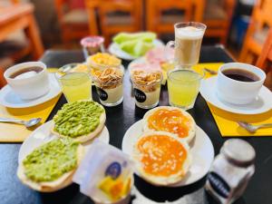 a table topped with plates of breakfast foods and drinks at Hotel Casa Lyon in Santiago