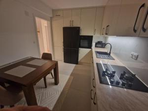 a kitchen with a table and a stove top oven at Apartman Djurić in Brčko +19 photos