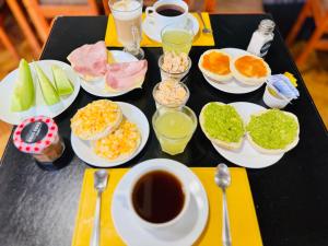 a table with plates of food and a cup of coffee at Hotel Casa Lyon in Santiago +39 photos