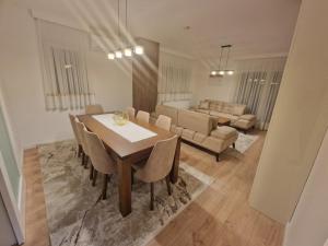 a dining room and living room with a table and chairs at Apartman Djurić in Brčko