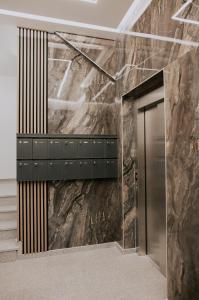 a elevator lobby with a large marble wall at Apartman Djurić in Brčko