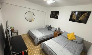 a bedroom with two beds and a mirror at Departamento céntrico y cómodo La Casona in Xalapa