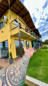 a person with a tattoo on their arm in front of a building at Village as casinhas in Uruçuca