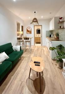 a living room with a green couch and a table at Casa Alba in Saint-Chamond