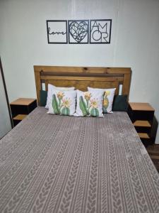 a bed with a wooden headboard and pillows at Casa completa in Caçapava do Sul