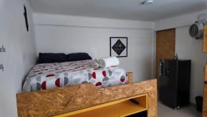 a bedroom with a bed and a refrigerator in it at Living Up in Puebla