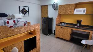 a room with a bed and a kitchen with a microwave at Living Up in Puebla