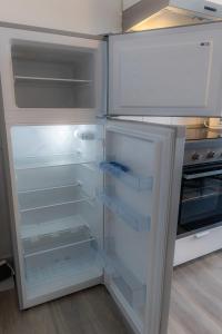 un frigorifero vuoto con lo sportello aperto in cucina di Kaiserbrunnen Gastromeile, City, Messe & Stadionnah a Dortmund