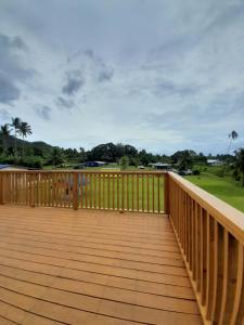 a wooden deck with a view of a golf course at PohatuOkoro in Arorangi