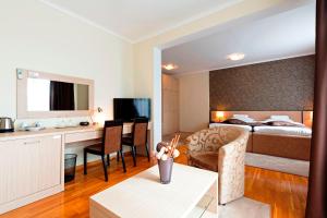 um quarto de hotel com uma cama e uma sala de estar em Garni Hotel Nevski em Belgrado