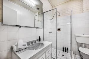 a white bathroom with a sink and a shower at Stunning Garden Studio at Mayfield Vineyard in Bloomfield