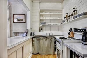 a kitchen with white cabinets and a stove top oven at Stunning Garden Studio at Mayfield Vineyard in Bloomfield