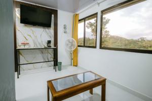 a living room with a tv and a window at Vista del Pacifico Boutique Hotel in Quepos