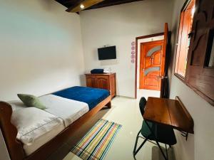 a bedroom with a bed and a table and a television at Hotel Jardin de Rosas in Jardin